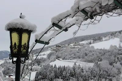 a street light covered in snow next to a mountain at Sonnleitn in Laion