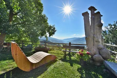a bench sitting in the grass next to a fence at Kircherhof in Bressanone