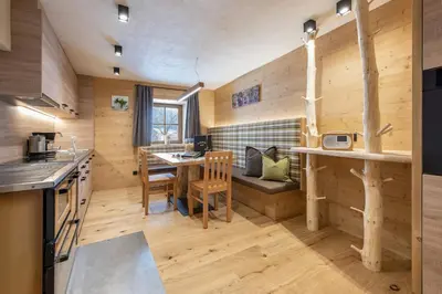 a kitchen and living room with a table and a couch at Kircherhof in Bressanone