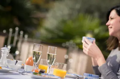 a woman sitting at a table with glasses of wine at Hotel Winzerhof in Termeno