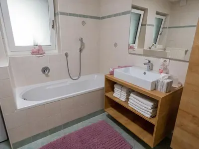 a bathroom with a tub and a sink and a mirror at Apartment Peskoller in Falzes