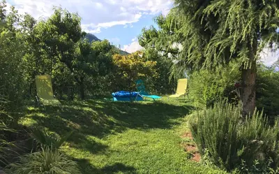 a shady yard with trees and a playground at Garni Rebhof in Nalles