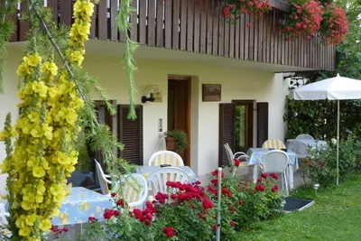 a patio with tables and chairs and flowers at Garni Rebhof in Nalles