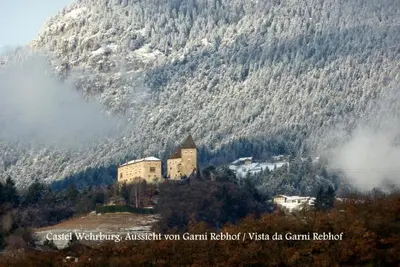 a castle on a hill in front of a mountain at Garni Rebhof in Nalles