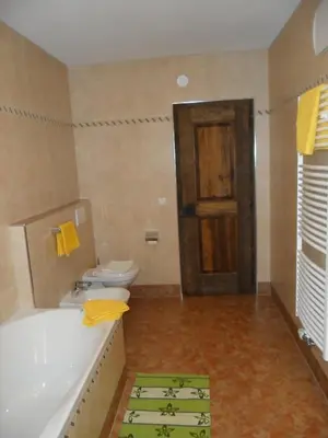 a bathroom with a tub and a toilet and a door at Appartamenti Stauderhof in Villabassa