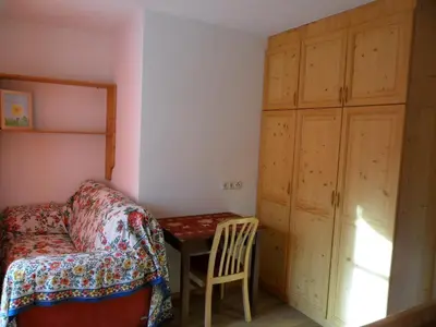 a bedroom with a table and a bed and a cabinet at Appartamenti Stauderhof in Villabassa
