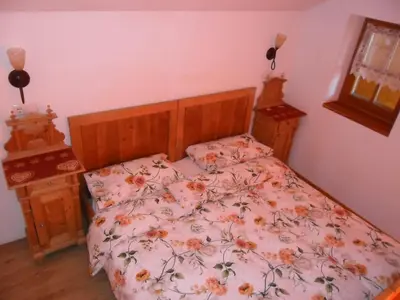 a bedroom with a bed with a floral bedspread at Appartamenti Stauderhof in Villabassa