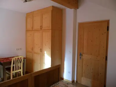 a room with a wooden closet and a table and a door at Appartamenti Stauderhof in Villabassa