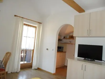 a living room with a television and a large window at Appartamenti Stauderhof in Villabassa