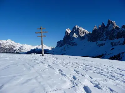 a cross on top of a snow covered mountain at Putzerhof in Funes