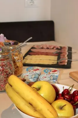 a bowl of fruit on a table with a plate of food at Gasthaus Oberkirn in Schenna