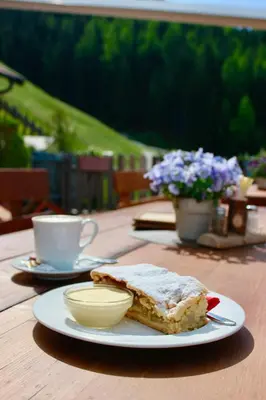 a plate with a piece of cake and a cup of coffee at Gasthaus Oberkirn in Schenna