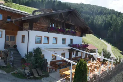 a building with a balcony with flowers on it at Gasthaus Oberkirn in Schenna