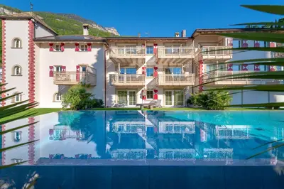 a hotel with a pool in front of a building at Überbacherhof in Termeno