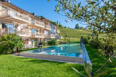 a swimming pool in a yard next to a building at Überbacherhof in Termeno