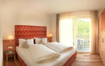 a bedroom with a large bed and a large window at Überbacherhof in Termeno
