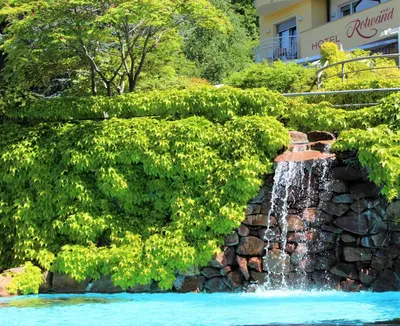 a waterfall in the middle of a stone wall at Gartenresidence Stephanie by Hotel Rotwand in Laives