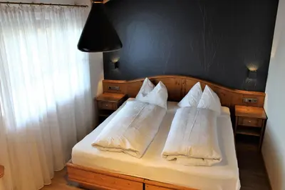 a bedroom with a bed with white pillows on it at Gartenresidence Stephanie by Hotel Rotwand in Laives