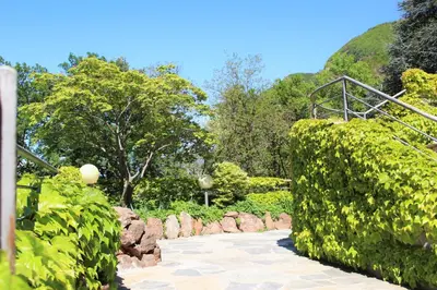 a walkway in a park with bushes and trees at Gartenresidence Stephanie by Hotel Rotwand in Laives