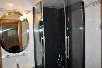 a bathroom with a shower with a mirror and a sink at Gartenresidence Stephanie by Hotel Rotwand in Laives