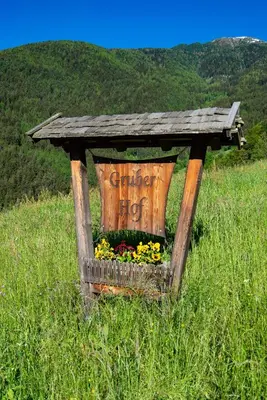 a wooden box with flowers in a field at Gruberhof a quiet place Gereuth Brixen in Bressanone