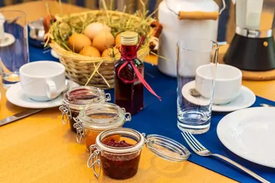 a table with a blue table cloth and eggs in a basket at Gruberhof a quiet place Gereuth Brixen in Bressanone