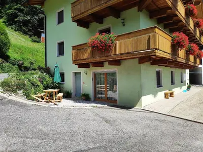 a building with a balcony with flowers on it at Gruberhof a quiet place Gereuth Brixen in Bressanone