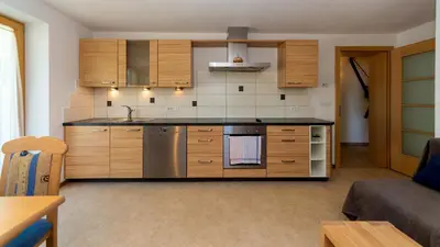 a kitchen with wooden cabinets and stainless steel appliances at Gruberhof a quiet place Gereuth Brixen in Bressanone