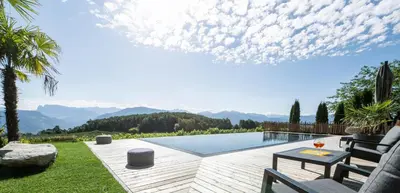 a backyard with a pool with a view of mountains at Apartments Schmalzerhof - Eppan an der Weinstraße in Appiano Sulla Strada Del Vino