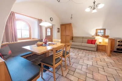 a kitchen and living room with a table and chairs at Apartments Schmalzerhof - Eppan an der Weinstraße in Appiano Sulla Strada Del Vino