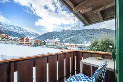 a balcony with a table and a view of a mountain at Garni Bondi in Selva di Val Gardena