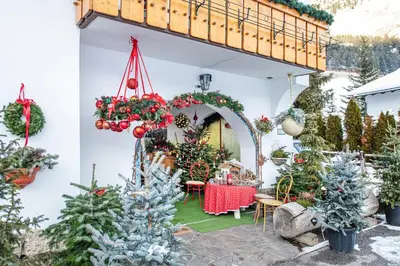a patio decorated for christmas with christmas trees at Garni Bondi in Selva di Val Gardena