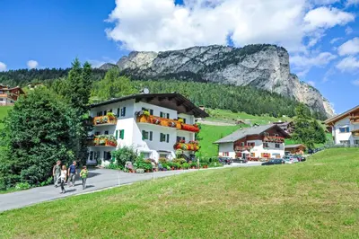 a group of people walking down a street in front of a building at Garni Bondi in Selva di Val Gardena