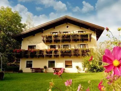 a large building with balconies and flowers in a yard at Garni Waldfrieden in Castelrotto