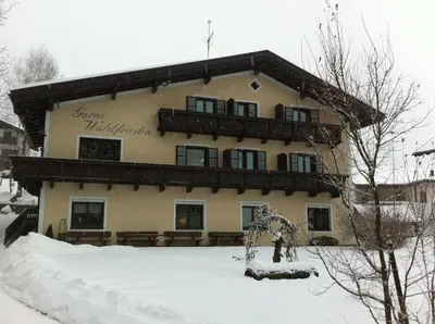 a large building with snow on the ground in front of it at Garni Waldfrieden in Castelrotto