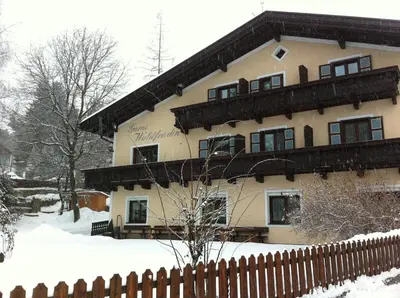 a building with a fence in the snow at Garni Waldfrieden in Castelrotto