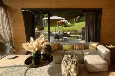 a living room with a couch and two horses grazing at Mi Chalet in La Villa