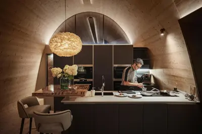a man standing in a kitchen preparing food at Mi Chalet in La Villa