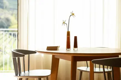 a table and chairs with a vase with a flower on it at Ladurnerhof Boutique Apartments Meran in Merano