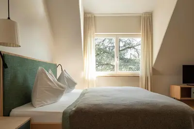 a bedroom with a bed and a window at Ladurnerhof Boutique Apartments Meran in Merano