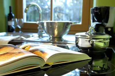 an open book sitting on a kitchen counter with a sink at Villa Tilia in Siusi