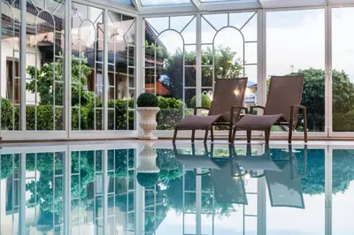 a pool with chairs next to a building at Hotel Oberbrunn in Naz-Sciaves