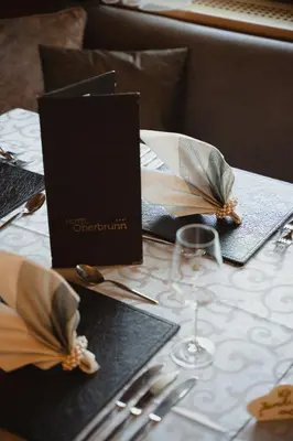 a table with napkins and a book on top of it at Hotel Oberbrunn in Naz-Sciaves