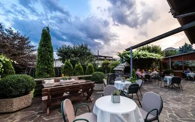 a patio with tables and chairs and people sitting at Hotel Oberbrunn in Naz-Sciaves