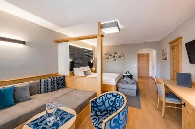 a living room with a couch and a bed at Hotel Oberbrunn in Naz-Sciaves