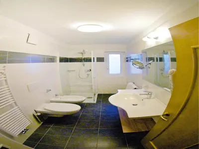 a bathroom with two sinks and a toilet and a shower at Amazing apartment house Diamant with breathtaking view in Santa Cristina in Val Gardena