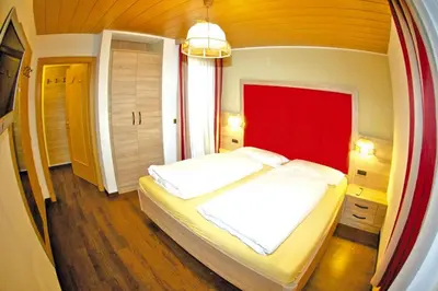 a bedroom with a large bed with a red headboard at Apartment in Val Gardena near Ski Slopes in Santa Cristina in Val Gardena