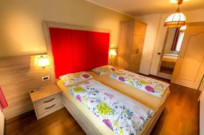 a bedroom with two beds and a red headboard at Apartment in Val Gardena near Ski Slopes in Santa Cristina in Val Gardena