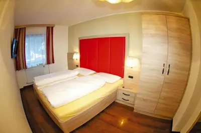 a bedroom with a large bed and a red cabinet at Apartment in Val Gardena near Ski Slopes in Santa Cristina in Val Gardena