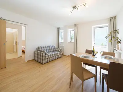 a living room with a table and a couch at Apartment in Dorf Tirol near tennis court in Tirolo